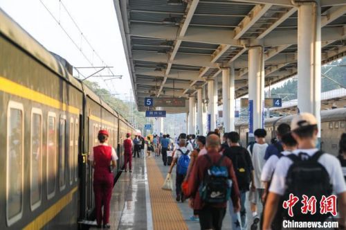 图为江西赣州站，旅客从站台上走过准备上车。中新网