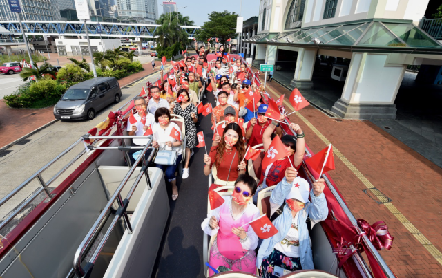 2021年10月1日，在喷鼻 港陌头 ，加入 庆贺 国庆巴士巡游的人们挥舞 国旗和喷鼻 港特戋戋 旗。 新华社 图